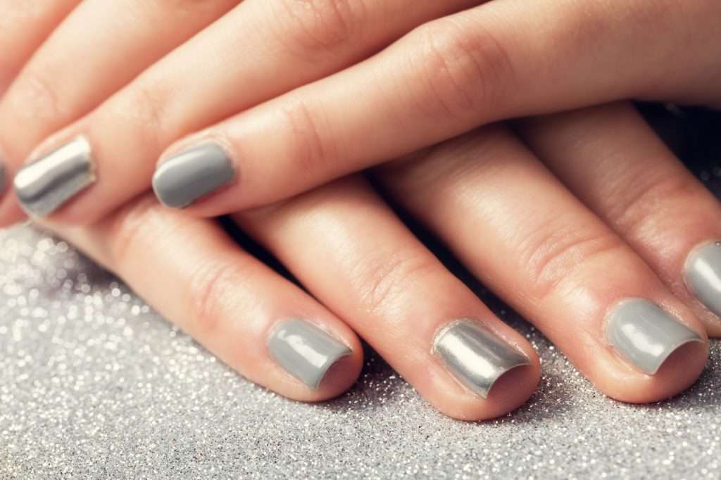 Woman's nails with shiny silver hybrid manicure